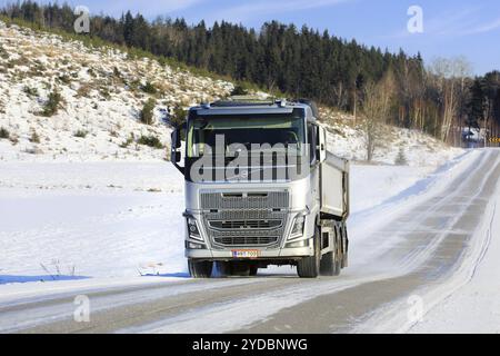 Silberner Volvo FH Schotterwagen mit hoher Geschwindigkeit auf Landstraßen an einem sonnigen Wintertag. Salo, Finnland. Februar 2024 Stockfoto