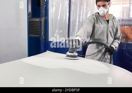 Auto Mechaniker tragen Gesichtsmaske Schwabbelung und Polieren Haube im Auto-Werkstatt Stockfoto