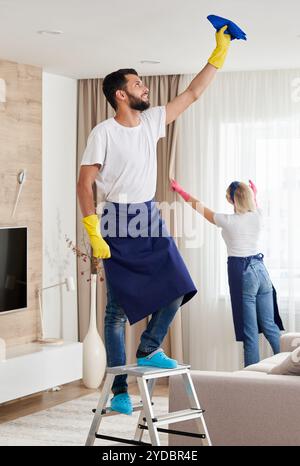 Professionelles Reinigungsservice-Team reinigt Wohnzimmer in modernen Wohnung Stockfoto