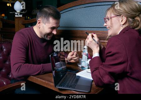 Glückliche Geschäftsleute, die in einem Restaurant am Laptop arbeiten Stockfoto