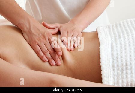 Rückenmassage. Masseur, der junge Frau auf Massagetisch im Spa-Salon massiert. Junge Frau, die sich während einer Rückenmassage im Spa entspannt. Stockfoto