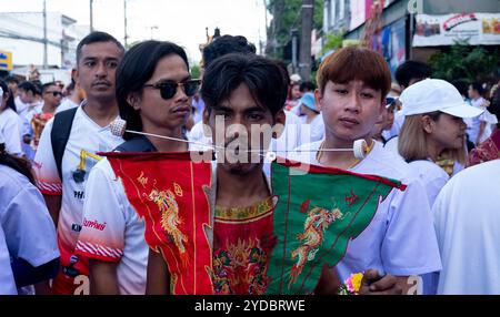 Ein Gläubiger läuft in einer Prozession, nachdem er während des jährlichen Vegetarian Festival in Phuket Town am Baan Tha Rua Schrein durchbohrt wurde. Das Festival brachte 15 Milliarden Thai Baht in die lokale Wirtschaft mit über 400.000 Besuchern ein. Stockfoto