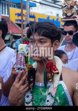 Ein Gläubiger läuft in einer Prozession, nachdem er während des jährlichen Vegetarian Festival in Phuket Town am Baan Tha Rua Schrein durchbohrt wurde. Das Festival brachte 15 Milliarden Thai Baht in die lokale Wirtschaft mit über 400.000 Besuchern ein. Stockfoto