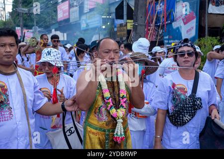 Ein Gläubiger läuft in einer Prozession, nachdem er während des jährlichen Vegetarian Festival in Phuket Town am Baan Tha Rua Schrein durchbohrt wurde. Das Festival brachte 15 Milliarden Thai Baht in die lokale Wirtschaft mit über 400.000 Besuchern ein. Stockfoto