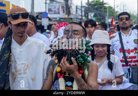 Ein Gläubiger läuft in einer Prozession, nachdem er während des jährlichen Vegetarian Festival in Phuket Town am Baan Tha Rua Schrein durchbohrt wurde. Das Festival brachte 15 Milliarden Thai Baht in die lokale Wirtschaft mit über 400.000 Besuchern ein. Stockfoto