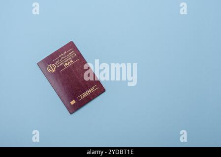 Physischer internationaler Pass von iranischem Staatsbürger auf blauem Hintergrund Stockfoto