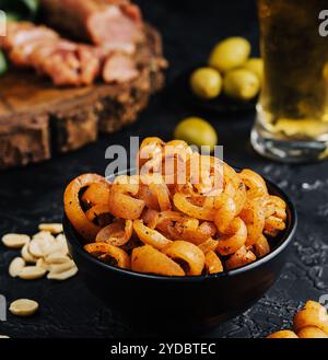 Schweinehohrensnack in der Schüssel mit Bier in einem Glas Stockfoto