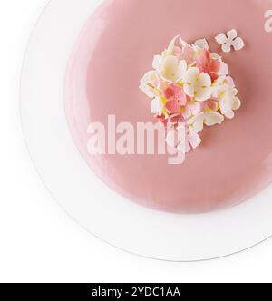 Rosafarbener Mousse-Kuchen mit Spiegelglasur, dekoriert mit Blumen Stockfoto