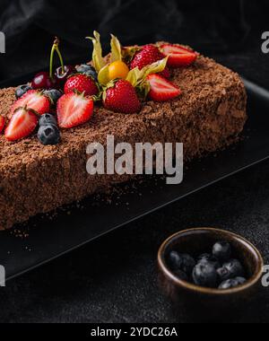 Schokoladen-Napoleon-Kuchen mit Beeren auf Steinteller Stockfoto