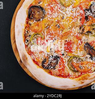 Vegane Pizza mit geröstetem Gemüse auf Holzbrett Stockfoto