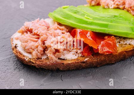 Toast mit Thunfisch aus der Dose und Avocado mit Tomaten Stockfoto