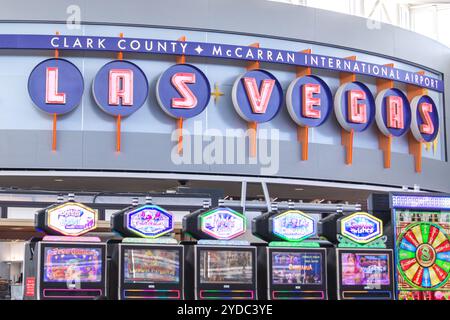 LAS VEGAS, NEVADA, USA - 13. MAI 2019: Spieler spielen Spielautomaten am McCarran International Airport Terminal unter einem Willkommen t Stockfoto