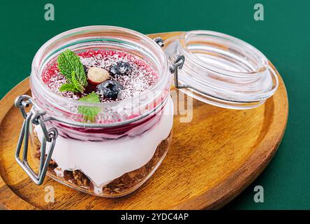 Müsli mit Nüssen, Joghurt und Beeren in einem Glas Stockfoto