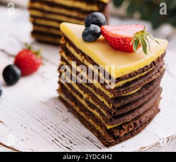 Köstlicher, frischer Schokoladenkuchen mit Beeren auf Holztisch Stockfoto