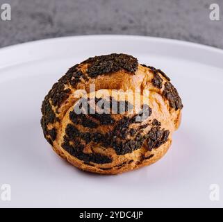 Ein Profiterole, französisches Choux-Gebäck überzogene Schokoladenchips Stockfoto