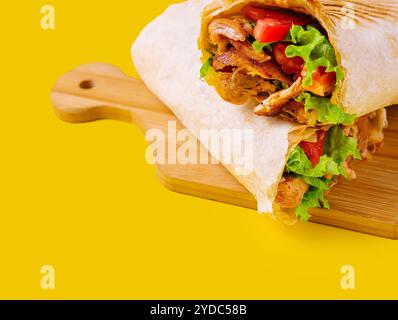 Shawarma mit Huhn, Tomaten und Salat auf einem Holzbrett Stockfoto