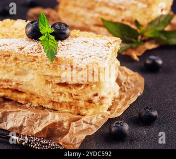 Gebackener Kuchen Napoleon, Millefeuille garniert mit Heidelbeere und Minze Stockfoto