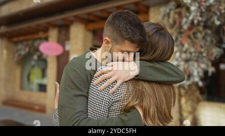 Liebevolle Mann und Frau, die sich auf einer geschäftigen Stadtstraße umarmen, Liebe und enge Beziehung in einer Outdoor-Umgebung zum Ausdruck bringen. Stockfoto