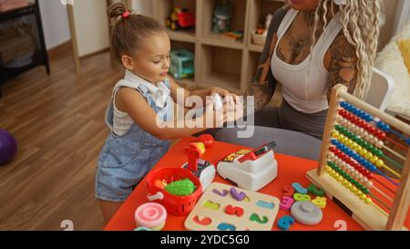 Das Mädchen im Spielzimmer interagiert mit der Mutter mithilfe von Spielzeug, Abacus und einer Kasse, um die Bindung der Familie in einer Bildungsumgebung zu betonen Stockfoto