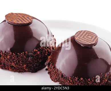 Kuchenscheiben in Schokoladenglasur isoliert auf weiß Stockfoto