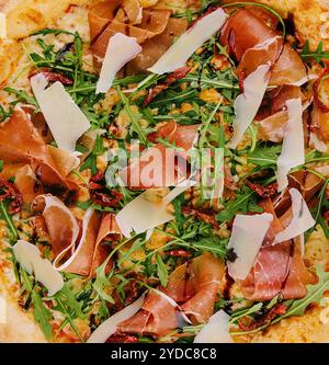 Pizza mit Schinken (parmaschinken), Rucola (Salatrakete) und Parmesan Stockfoto