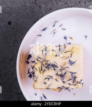 Französischer Mille-Feuille-Kuchen mit Vanillecreme, verziert mit blauen Blütenblättern Stockfoto