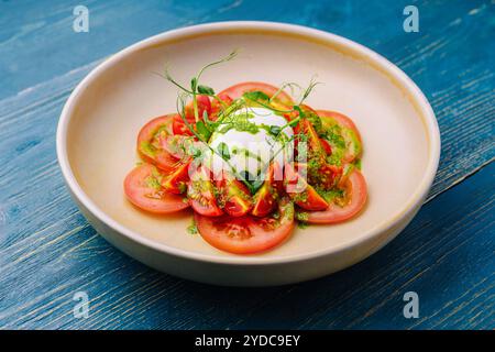 Salat mit Burrata-Käse und Tomaten auf Teller serviert Stockfoto