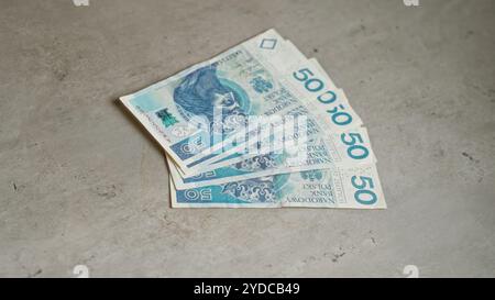 Die polnischen 50 Zloty-Banknoten wurden auf einer Betonoberfläche aufgefächert und zeigen die Währung und den wirtschaftlichen Wert polens. Stockfoto