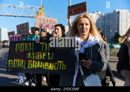 Ukrainische Frau posiert mit einem Poster, das den gefangenen Verteidigern von Mariupol gewidmet ist, die trotz Vereinbarungen seit 2022 in russischer Gefangenschaft bleiben. Kiew - 20. Oktober 2024 Stockfoto