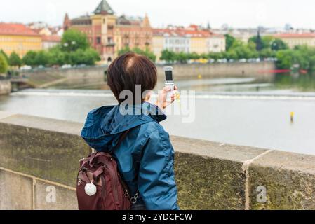 Frau macht Fotos auf der Karlsbrücke in Prag Stockfoto