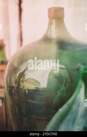 Alte, leere Weinflaschen hinter dem Glas Stockfoto