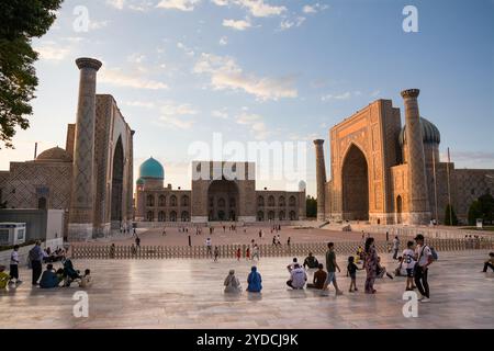 Samarkand, Usbekistan - 5. Juli 2024: Die drei Portale mit ihren Madrasas auf dem Registan-Platz von Samarkand bei Sonnenuntergang und die Touristen Stockfoto