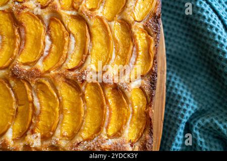 Ein Dessert aus geschnittenen Pfirsichen ist auf einem hölzernen Schneidebrett. Das Dessert ist mit Zucker bedeckt und sieht köstlich aus. Stockfoto
