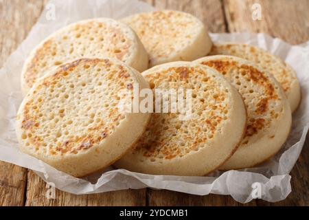 Tradition heiße gebutterte Crumpets Nahaufnahme auf Pergament auf dem Tisch. Horizontal Stockfoto