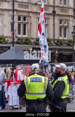 Westminster, London, Großbritannien. Oktober 2024. Anhänger von Stephen Yaxley-Lennon (auch bekannt als Tommy Robinson) treffen sich vor dem Bahnhof Victoria zu einem protestmarsch nach Whitehall. Themen des Protestes sind die Einwanderung, und ein von Stand Up to Rassismus organisierter Widerstand soll bis zum anderen Ende von Whitehall marschieren. Polizeieinheiten der Metropolitan Police bauen ihre Präsenz in der Region aus, um Gewalt abzuschrecken. Robinson steht wegen angeblicher Missachtung des Gerichts vor dem Gefängnis. Polizisten in Whitehall Stockfoto