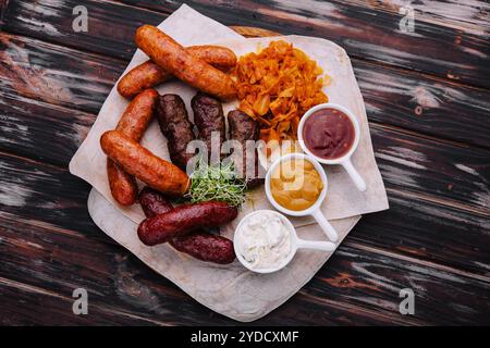 Bierset mit gegrillten Würstchen mit gedünstetem Kohl und Saucen Stockfoto