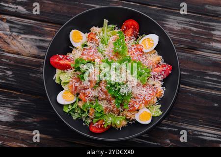 Salat mit Lachs, Salat, gekochten Eiern, Kirschtomaten und Parmesankäse Stockfoto