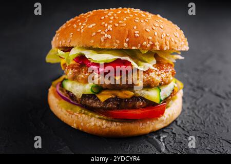 Burger mit zwei Schnitzeln und frischem Gemüse Stockfoto