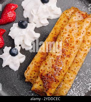 Pfannkuchen auf einem Teller mit Erdbeeren, Schlagsahne Stockfoto