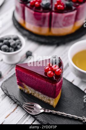 Beeren-Mousse-Kuchen mit roter Glasur und Tee Stockfoto