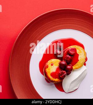 Hüttenkäsepfannkuchen mit Beerenmarmelade und Sauerrahm Stockfoto