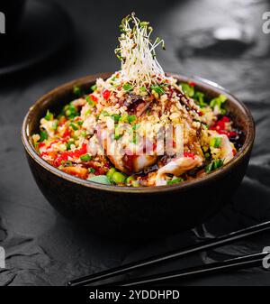 Salat mit Aal und Couscous auf schwarzer Schüssel Stockfoto