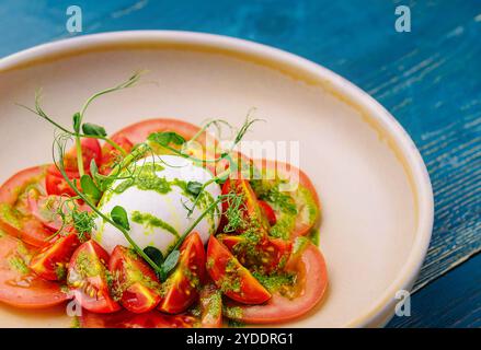 Salat mit Burrata-Käse und Tomaten auf Teller serviert Stockfoto