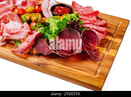 Verschiedene Fleischsorten, Würstchen, Salami, Schinken, Oliven, auf einem Holzbrett Stockfoto