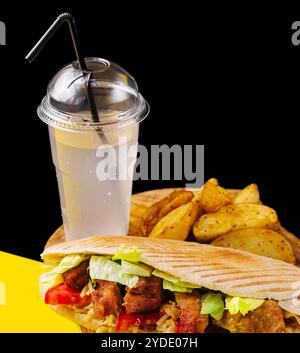 Leckerer Hühnchendöner mit gebratener Kartoffel auf einem Holztisch Stockfoto