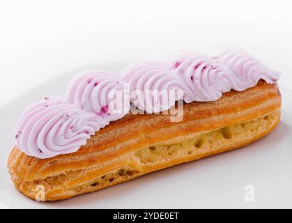 Eclair schlug rosa Sahne auf Teller Stockfoto