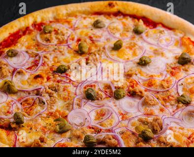 Köstlicher Pizza Thunfisch mit Tomaten, Oliven, Zwiebeln und Kapern Stockfoto