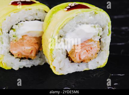 In Avocado gewickelte Brötchen mit gebratenem Lachs Stockfoto