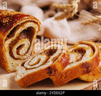 In Scheiben geschnittenes Brötchen mit Apfelmarmelade auf Holzbrett Stockfoto