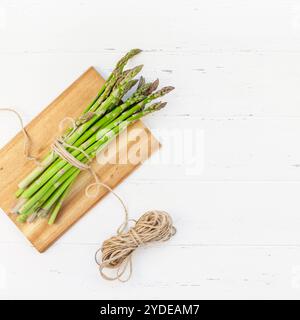 Frischer grüner Spargel auf weißem Holzhintergrund Stockfoto